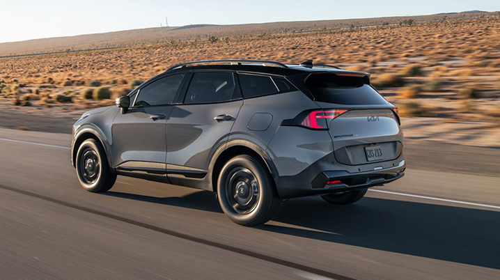 2025 Kia Sportage rear view driving Texas highway, new Kia Sportage for sale Fort Worth, Kia SUV rear boomerang lights, Kia Sportage crossover comparison with Tucson, Sportage exterior design in DFW, Kia SUV with AWD for Texas roads, Sportage vs Tucson SUV buying guide, Kia Sportage road test in Fort Worth