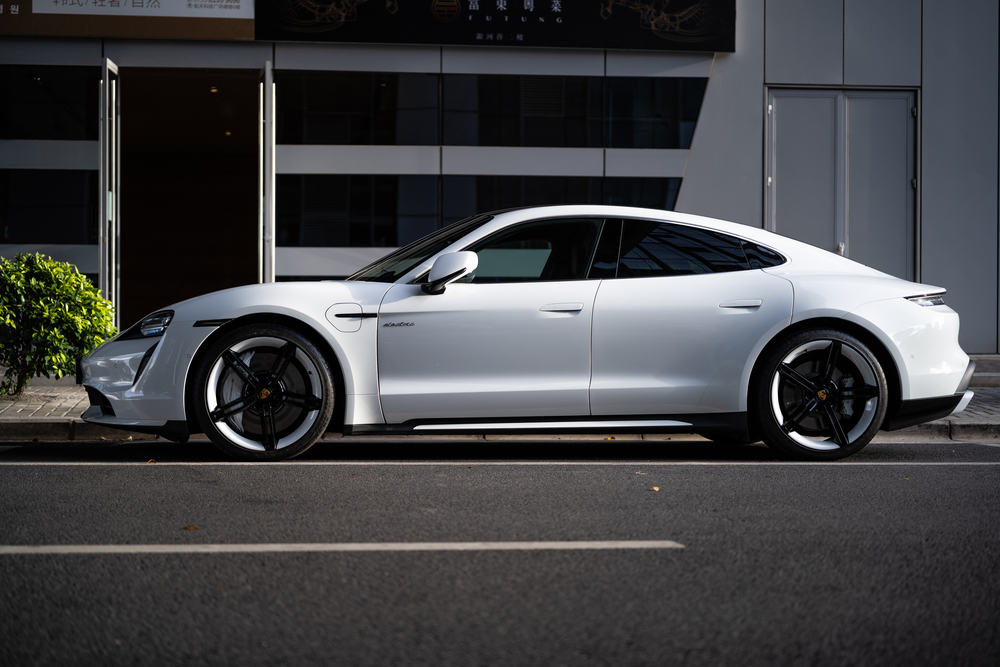 2025 Porsche Taycan side profile white, electric luxury car Fort Myers streets, Porsche Taycan design details, Taycan parked downtown Fort Myers, Porsche EV for daily driving Florida, Porsche Taycan sleek silhouette