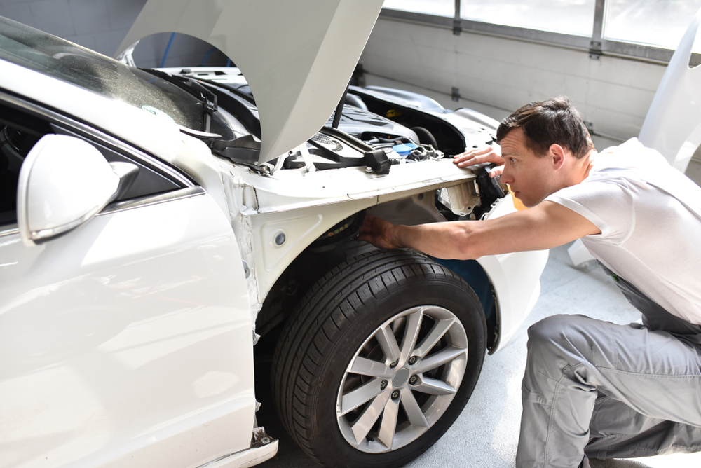 Athens GA collision repair technician, fender bender repair Athens Collision Center, auto body shop technician inspecting damage, professional vehicle damage assessment Athens Georgia, certified collision technician for summer accidents Athens
