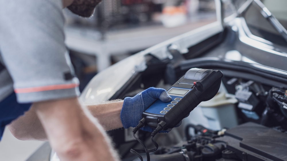 Certified Nissan technician performing battery test, summer car battery check Athens GA, Nissan of Athens Service Center battery diagnostic, OEM Nissan battery replacement Georgia, dealership battery inspection for Nissan Altima Sentra Rogue, professional battery service Athens Nissan dealership