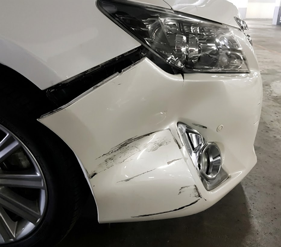 close up of white luxury car with dented front bumper, scraped fascia and damaged headlight, deer collision damage example, BMW front end impact, hidden ADAS sensor damage, Long Island deer strike body damage, bumper repair Freeport NY, BMW deer collision repair Nassau County, front bumper accident damage inspection, BMW of Freeport Collision Center repair example