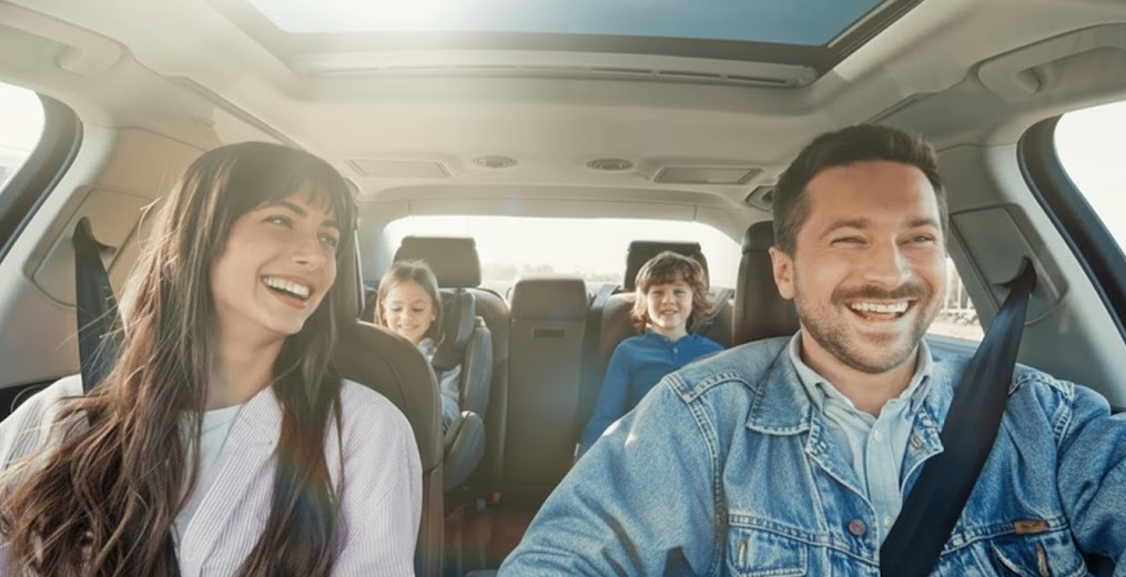 Smiling family riding together in spacious BMW style SUV, confident winter driving after professional battery service, reliable BMW interior on Long Island highway, parents and children enjoying safe trip near Freeport NY, family car ready for cold weather after BMW battery testing and registration, peace of mind from BMW of Freeport Service Center, dependable BMW for Nassau County winter commuting