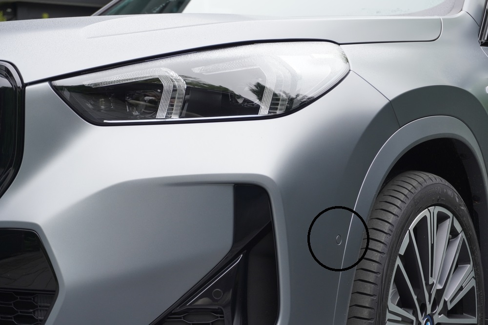 Close-up of BMW front bumper with parking sensor, BMW ADAS radar alignment, BMW sensor recalibration after LIE fender bender, front-end camera calibration Freeport NY, minor collision sensor shift