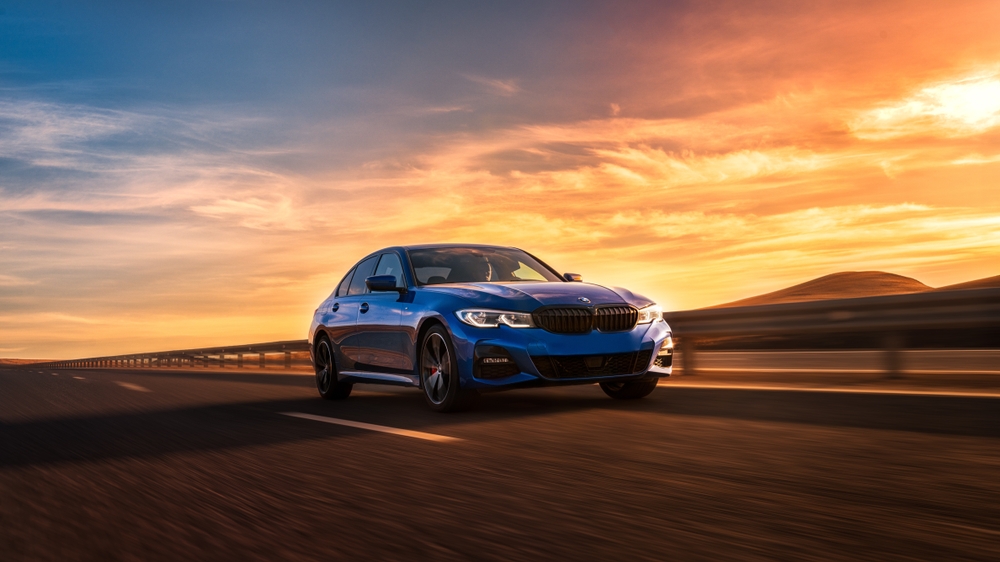 BMW summer drive Long Island, BMW safety road trip New York, BMW sedan on highway at sunset, safe braking BMW summer travel, 2025 BMW performance driving, brake confidence for summer roads