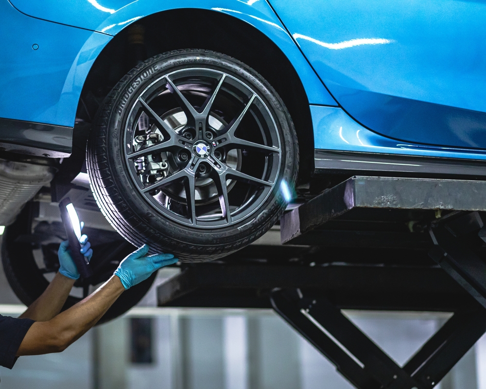 BMW vehicle on lift undergoing alignment inspection, BMW sensor recalibration after collision Freeport NY, certified ADAS calibration Long Island, wheel alignment affects radar and camera sensors