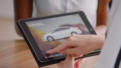 Dealership service advisor showing ProPILOT Assist info on tablet, customer consultation, schedule ADAS calibration, Nissan service Conyers GA, Rockdale County dealership, certified technicians, factory parts, service specials, book calibration online