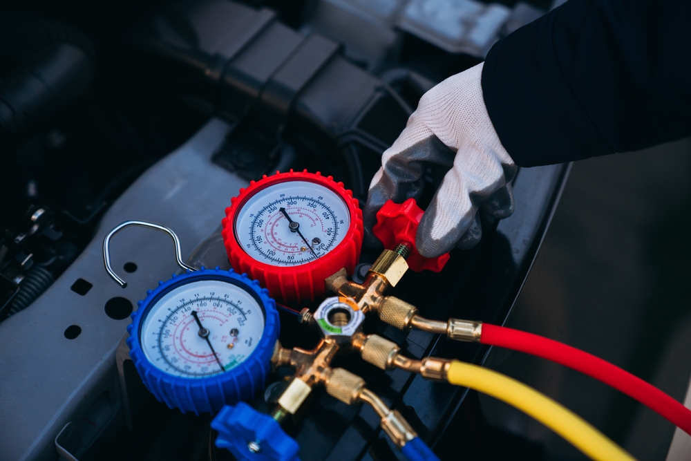 Technician using refrigerant gauge for Mazda A/C recharge, Mazda air conditioning inspection Daytona Beach, OEM-certified technician Florida, Mazda refrigerant service FL, high pressure gauge Mazda A/C service, cooling system recharge Mazda