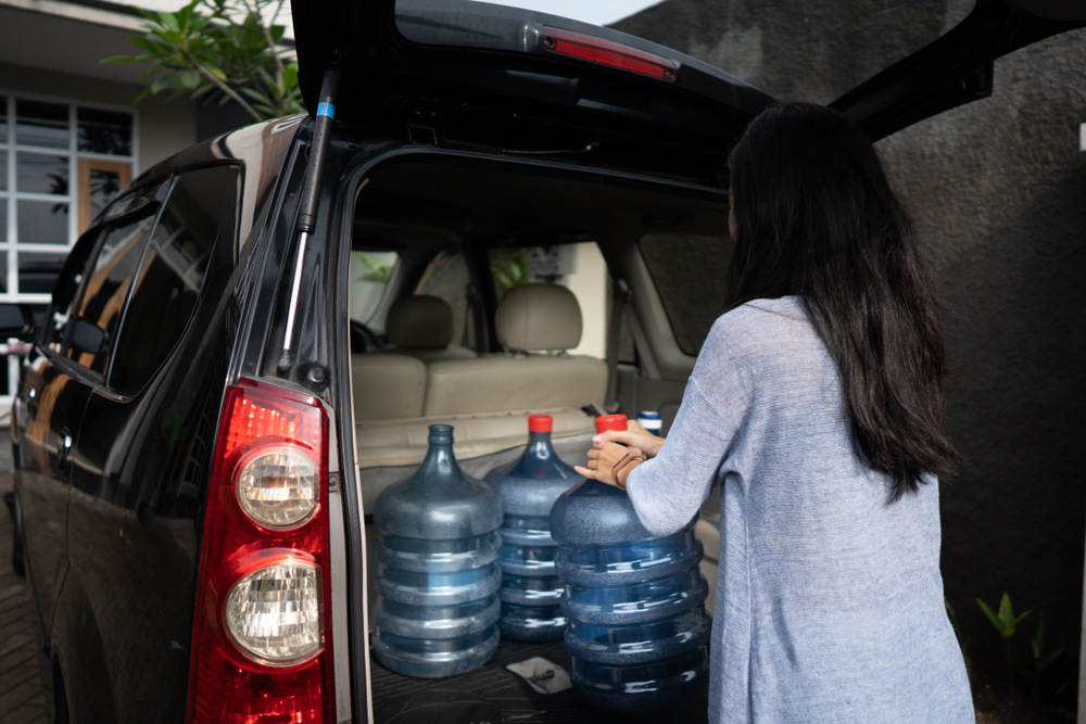 Mazda hurricane emergency kit, loading storm supplies into SUV, Daytona Mazda hurricane season checklist, evacuation preparation Mazda CX-5, Florida storm readiness Mazda, water storage emergency prep Mazda, Daytona Beach hurricane evacuation supplies
