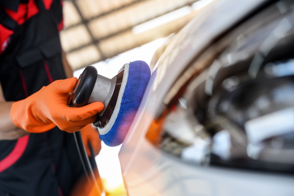 Technician buffing Mazda paint, professional paint correction Daytona Mazda Service, ceramic coating application, UV damage repair Florida, restore gloss and clear coat, Mazda dealer detailing Daytona Beach, protect against oxidation and sun fade