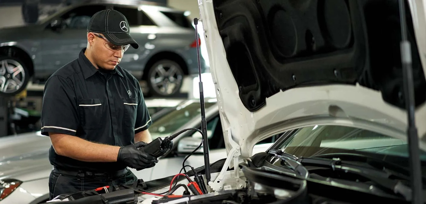 Mercedes technician testing battery, complimentary battery check Daytona, Mercedes-Benz diagnostic equipment, cold cranking amps reserve capacity internal resistance, prevent breakdown during evacuation, factory-trained service, genuine Mercedes parts, Daytona Mercedes Service hurricane prep inspection