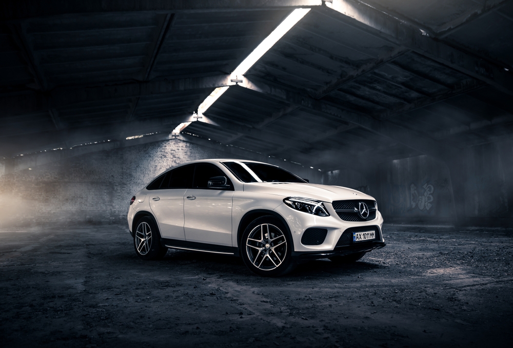 Mercedes-Benz SUV storm ready in Florida, Mercedes hurricane prep Daytona Beach, luxury car severe weather photo, protect Mercedes before hurricane, Mercedes service near me, Florida coastal storms, Mercedes-Benz safety, Daytona Mercedes Service hurricane preparation guide, storm clouds palm trees coastal road