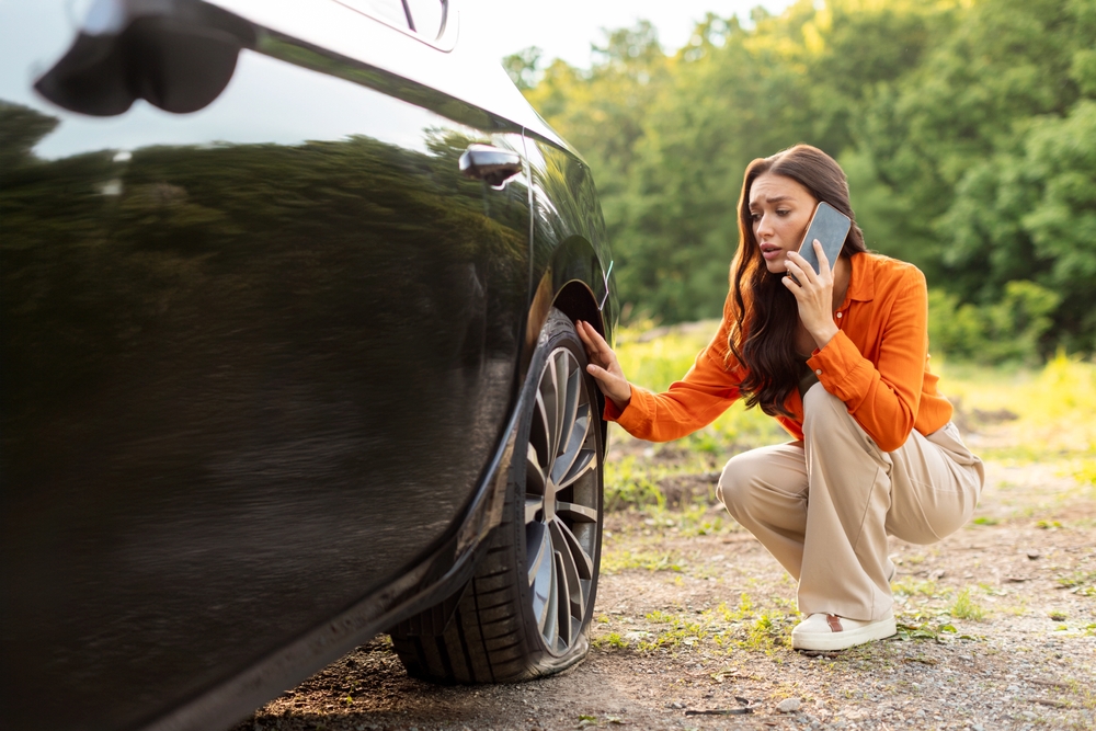 Flat tire emergency Georgia road, summer tire blowout Newnan GA, stranded driver checking tire damage Coweta County, heat-damaged tires Newnan Peachtree CDJR service, flat tire safety Georgia summer roads, emergency roadside assistance Chrysler Jeep