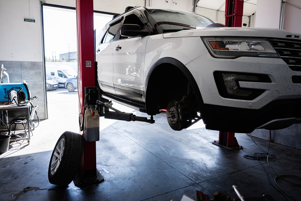 Ford of Murfreesboro service center, Ford SUV on lift in repair bay, brake and suspension service Murfreesboro TN, EcoBoost maintenance and tire rotation, Ford certified technicians Rutherford County, OEM Motorcraft parts, Ford Explorer service Murfreesboro, dealership auto repair Tennessee, factory-trained inspection and diagnostics