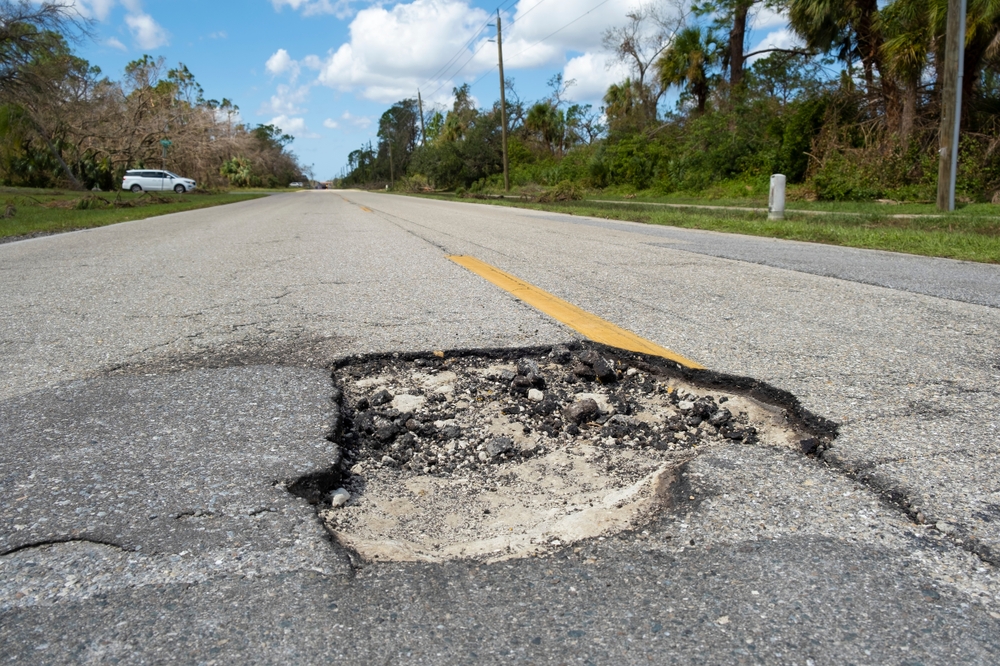 Freeport NY pothole road damage, Long Island potholes BMW tire alignment, BMW misalignment road hazard Nassau County, cracked pavement Freeport road hazard, wheel misalignment cause BMW, back to school BMW driving safety