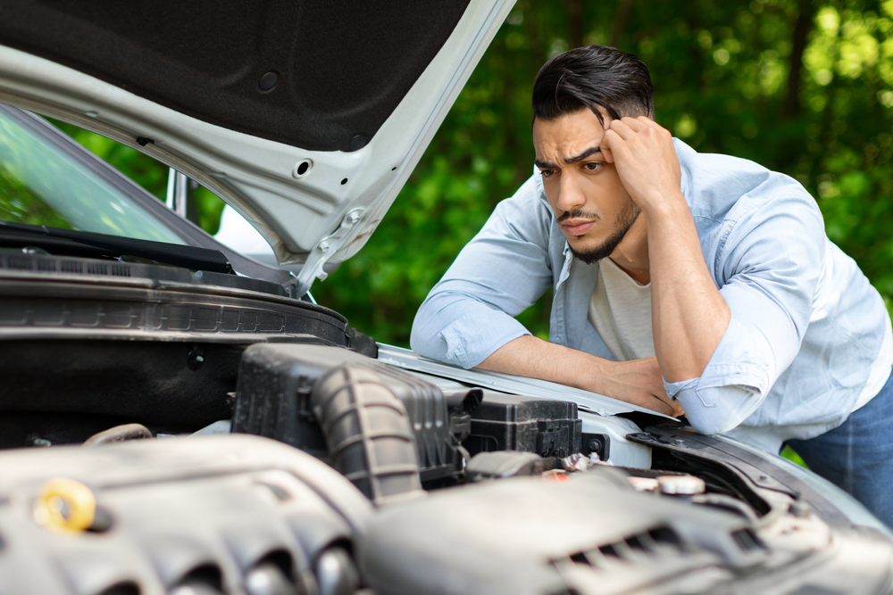 Frustrated driver car battery problem Conyers GA, Georgia heat car won’t start, Nissan battery failure roadside, stranded vehicle in summer, signs of bad car battery Georgia, car trouble hot weather, Nissan owner battery issues Conyers Nissan Service Center