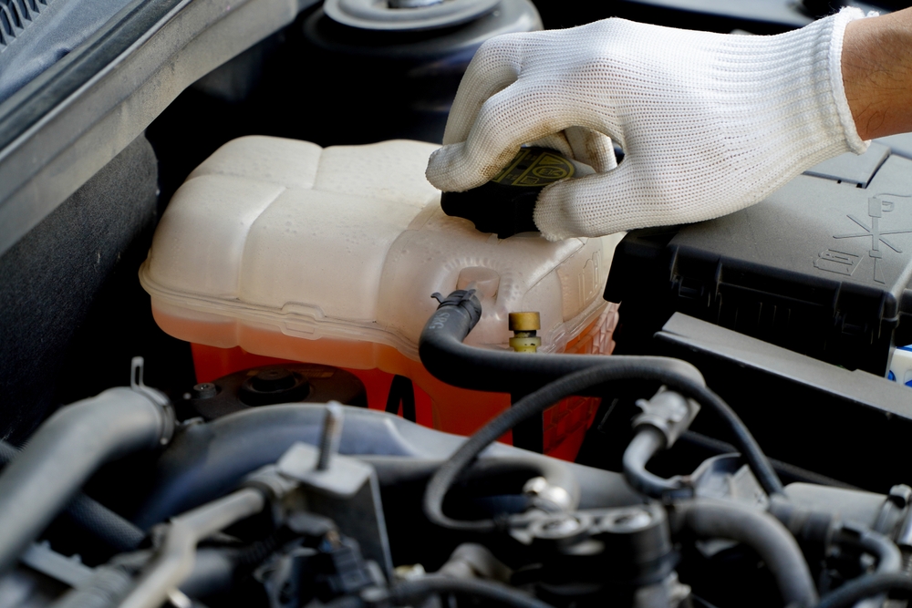 Nissan cooling system inspection Gainesville FL, professional car maintenance Florida heat, summer vehicle checkup Gainesville Nissan, coolant level check Nissan, engine overheating prevention Florida, car service hot weather tips, Gainesville car technician coolant reservoir, Nissan fluid management maintenance
