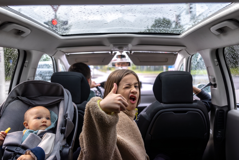 family driving in rain Gainesville FL, child safety seats and clear visibility, defroster clearing foggy windshield, Gainesville Nissan Service rainy season checklist, cabin air filter and climate control check, safe wet weather driving near Butler Plaza, Nissan SUV interior in storm, Gainesville Florida thunderstorms