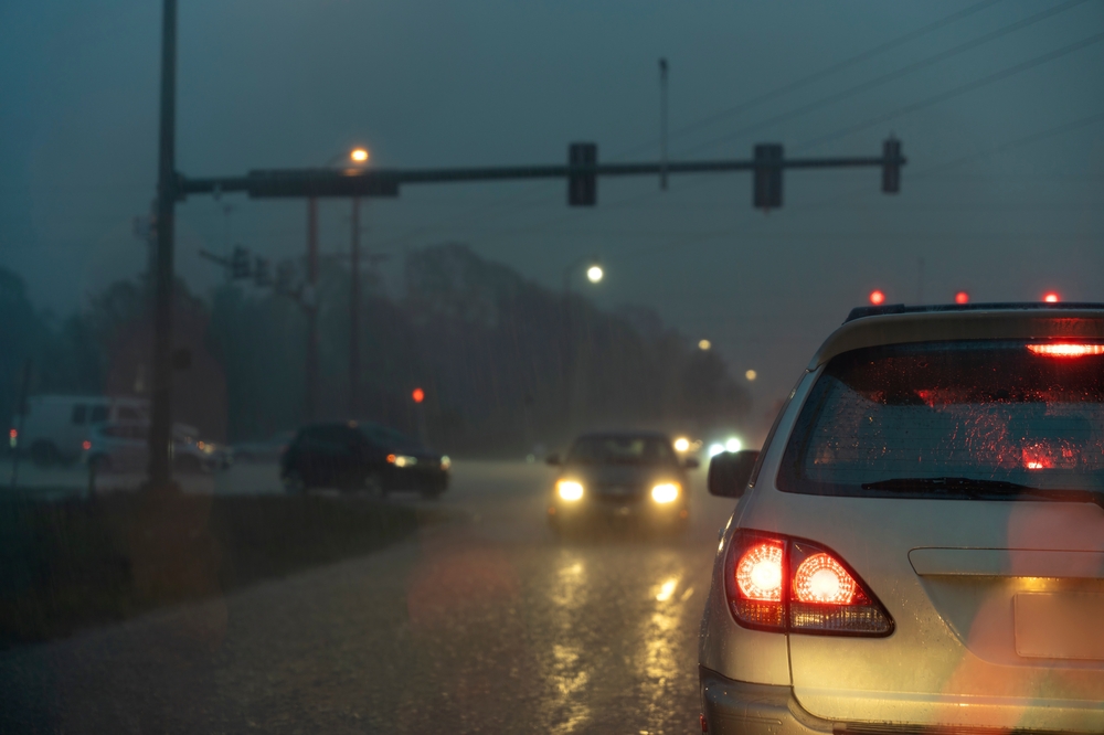 Florida rainstorm night driving, headlights on with wipers law, Gainesville traffic in heavy rain, visibility and wet weather safety, hydroplaning risks on University Avenue and I-75, Gainesville Nissan Service rainy season tips, wet weather driving Gainesville FL, brake lights and reflective road spray, AAA wet weather safety
