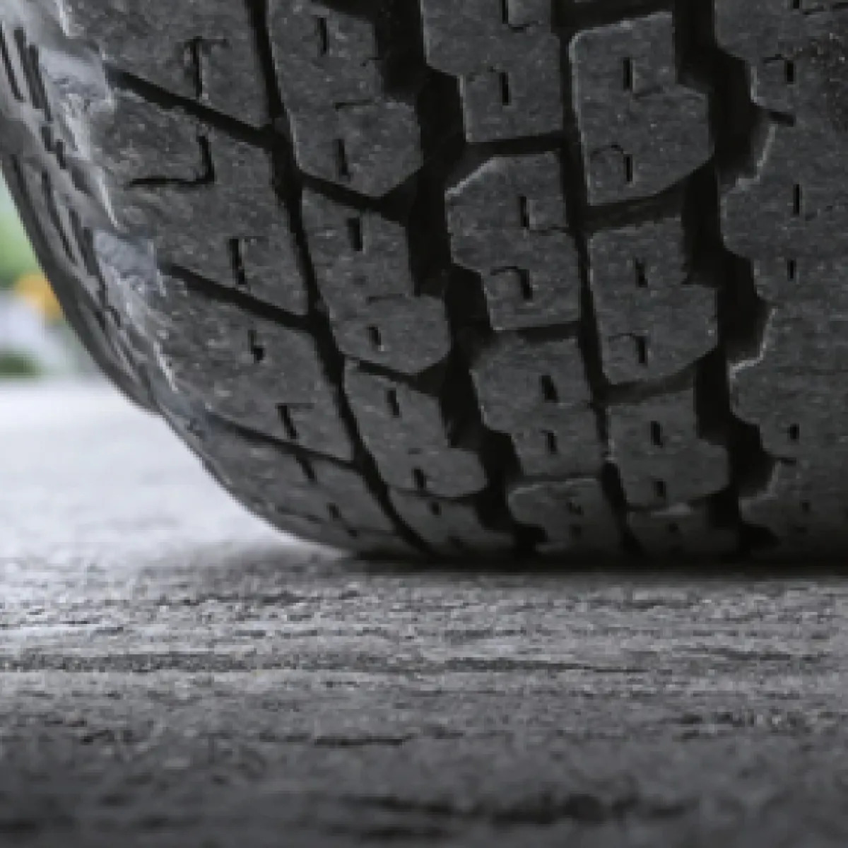 close-up of Nissan tire contacting road surface, proper tire tread and inflation for Gainesville driving, cold weather tire pressure drop example, safe traction on wet Florida roads, tire wear inspection Gainesville Nissan, Nissan TPMS and tire care, highway safety before Holiday travel in North Florida