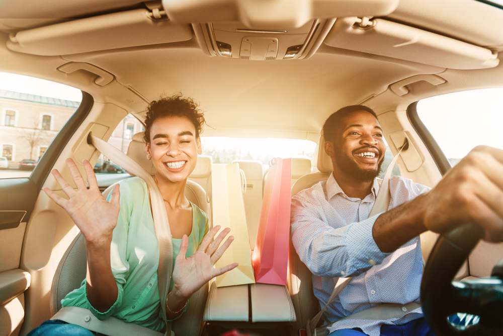 Happy couple driving Nissan car in Athens GA summer, reliable battery performance Nissan Altima Rogue, protected Nissan battery hot Georgia weather, family driving experience Athens Nissan dealership, carefree road trip Athens Georgia, shopping trip powered by new Nissan battery
