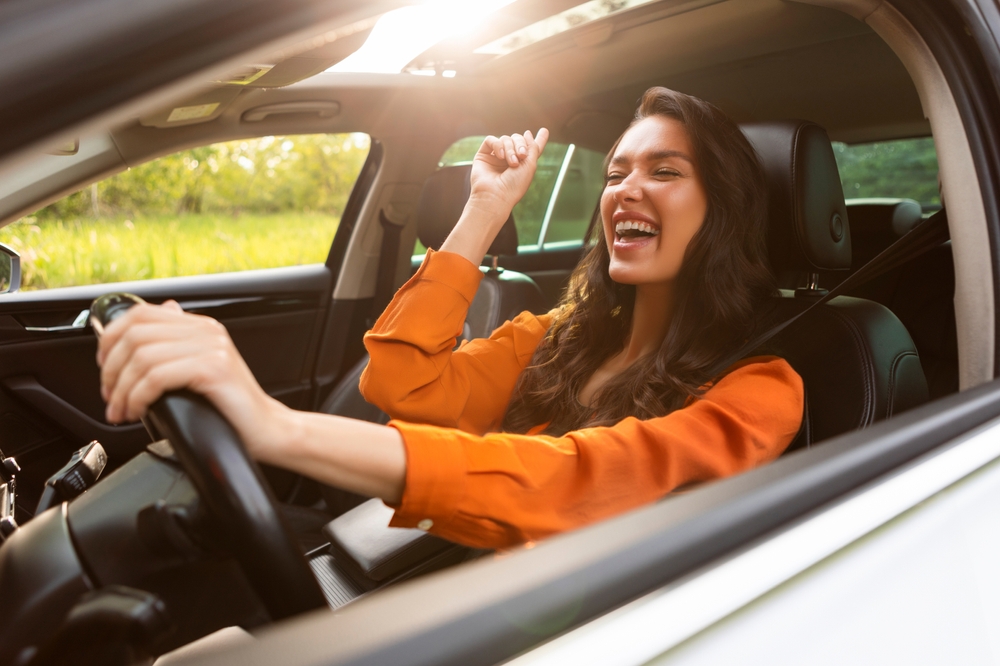 Happy female driver Newnan GA, safe summer driving Chrysler Dodge Jeep Ram, properly inflated tires Georgia heat, stress-free driving Newnan Peachtree CDJR tire inspection, road trip safety tips Georgia summer, heat-resistant tires performance