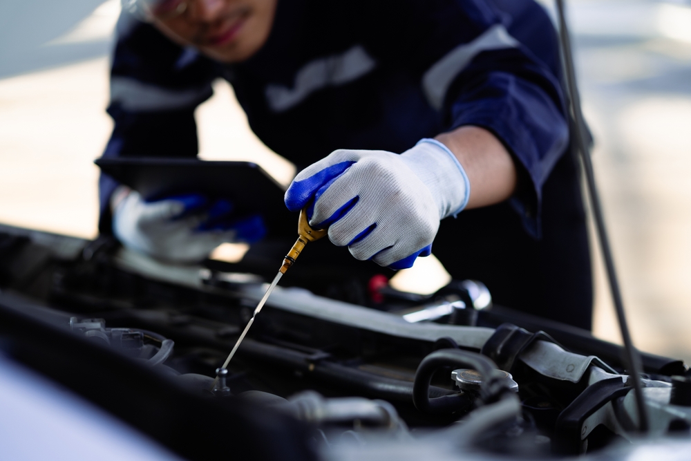 Honda technician checking oil dipstick, certified Honda service Louisville KY, Honda engine performance check, same-day Honda oil change, summer vehicle inspection Honda, oil level and quality test Honda, Honda maintenance minder service, expert Honda service Louisville Honda World, synthetic oil check Honda vehicle, fuel-efficient Honda service preparation