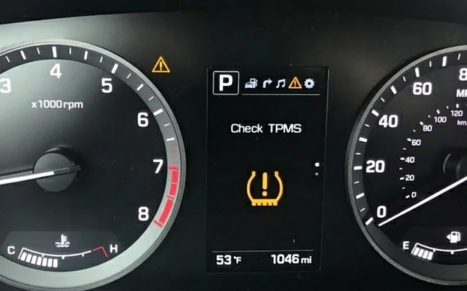 Hyundai dashboard close up with yellow TPMS warning light, Check TPMS message on instrument cluster, Hyundai tire pressure monitoring system alert on cool 53 degree morning, TPMS light solid yellow in Hyundai SUV or sedan, low tire pressure due to October temperature drop Charlotte NC, Hyundai driver sees tire pressure warning while backing out of Pineville driveway, modern Hyundai digital gauge cluster with TPMS icons, reminder to schedule tire pressure check at South Charlotte Hyundai Service Center, Hyundai safety technology for tires and sensors, dashboard warning lights explanation for Charlotte area Hyundai owners