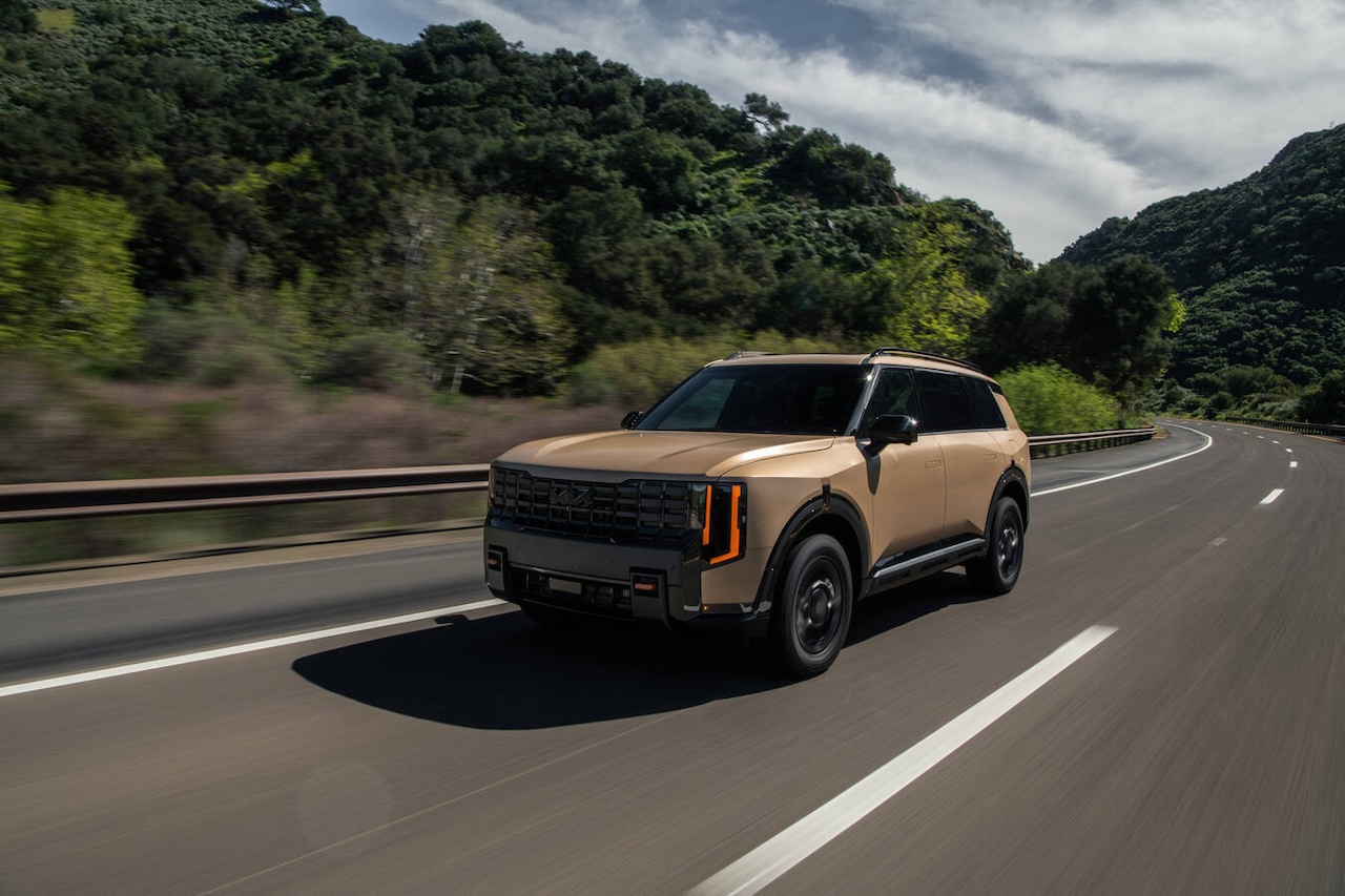Tan Hyundai Palisade driving on a road near AutoFair Hyundai in Manchester, NH.