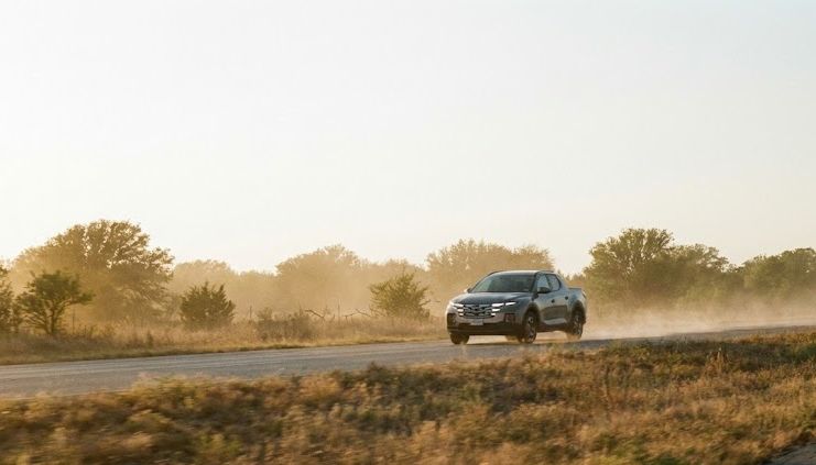 Hyundai truck driving on rural North Texas road in dusty air, Fort Worth ragweed pollen and construction dust, Texas highway conditions, protecting passengers from outdoor allergens, Hyundai SUV and truck drivers near Dallas Fort Worth, Alliance Hyundai Service Fort Worth TX, cabin air filter protection from pollen clouds, fall allergy season commute in North Texas