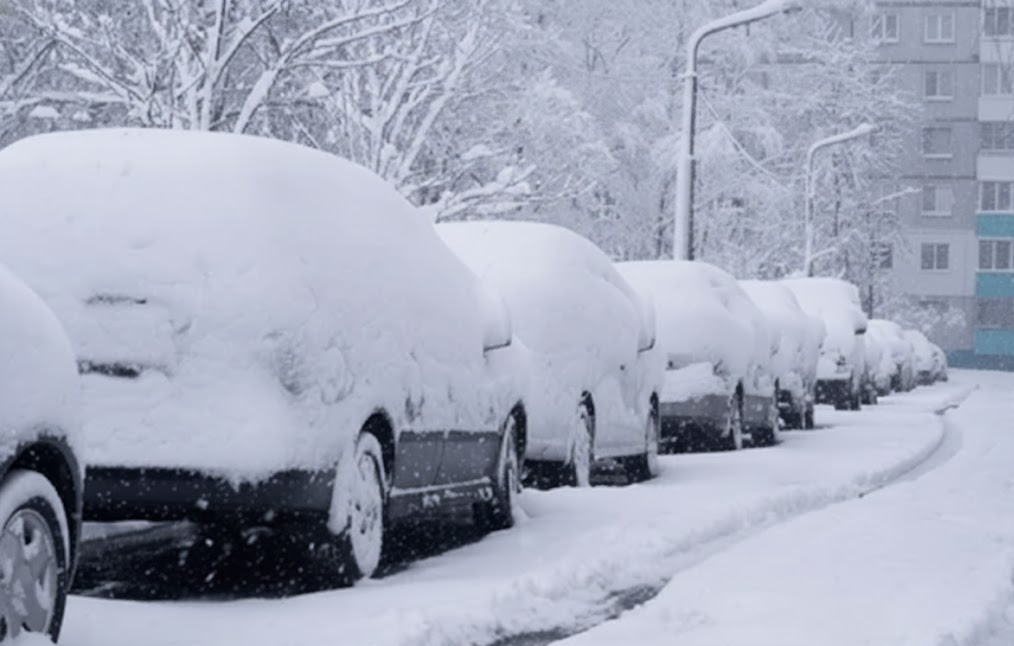 snow covered cars parked on Long Island street, dangerous winter driving conditions Massapequa NY, Nassau County icy roads, drivers caught without winter tires, cold weather below 45 degrees, winter storm on Sunrise Highway, snowy morning commute near Mercedes-Benz of Massapequa Service Center, need for proper winter tire installation, Long Island winter road safety, New York coastal snow and ice, frozen parked vehicles needing better tire traction