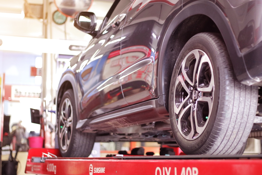 Kentuckiana Maintenance Calendar Summer service, Honda SUV on lift for A/C recharge, cooling system check Louisville KY, certified Honda summer maintenance Kentucky