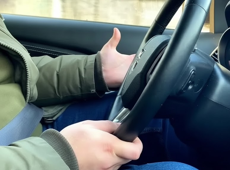 Driver holding steering wheel that sits slightly off-center, steering pull and drifting on Long Island roads, Mercedes-Benz SUV interior, signs of bad wheel alignment, Southern State Parkway effect on suspension, Massapequa driver feeling vibration in steering, Mercedes-Benz 4MATIC system working harder, reasons to schedule alignment check at Mercedes-Benz of Massapequa Service Center