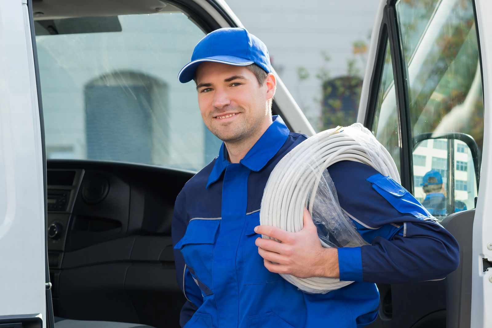 Electrician retrieving tools and wire from a well-organised Mercedes-Benz Sprinter cargo van