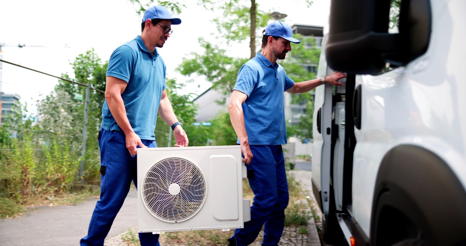 HVAC technician loading equipment from a fully upfitted Mercedes-Benz Sprinter cargo van at a Denver job site