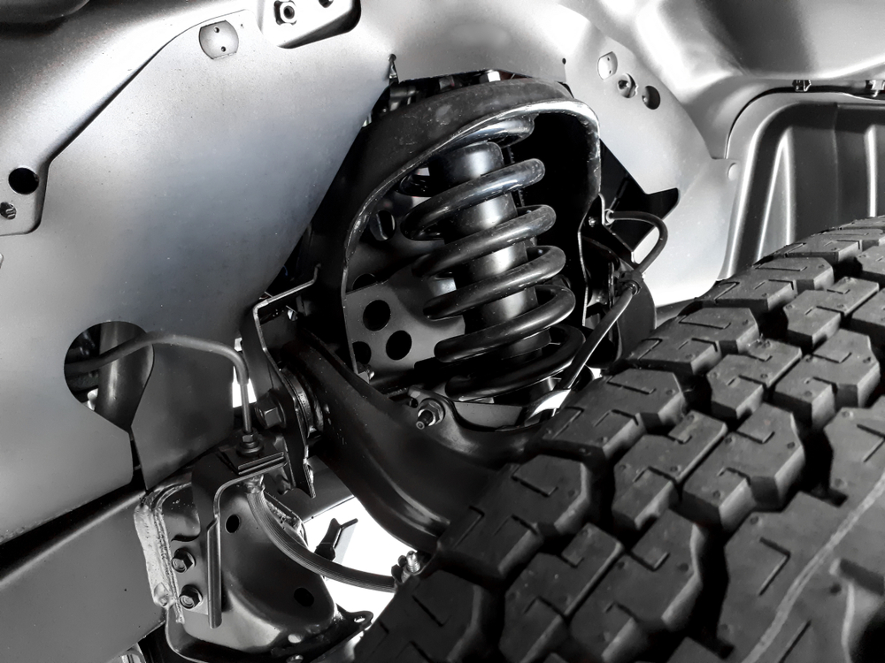 Ram 1500 suspension and tire pressure for towing, coil spring and truck tire close-up, alignment and tread depth checks, safe trailer hauling Newnan GA, Ram 1500 stability maintenance, pre-tow checklist Georgia roads, Newnan Peachtree CDJR service