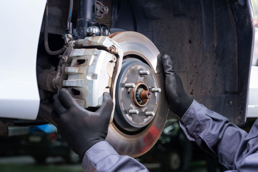 Nissan technician performing brake inspection at Knoxville service center before final brake repair appointment booking