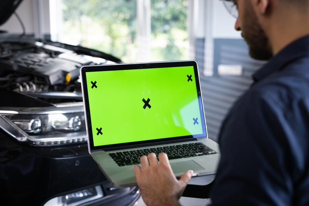 Auto technician using diagnostic software on Nissan, key fob signal test, key programming Charlotte NC, Nissan dealer diagnostic laptop, East Charlotte Nissan tech diagnosing key issue
