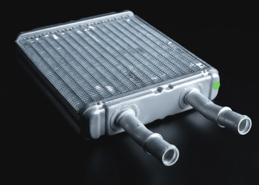 Close up Nissan heater core part, aluminum heater core cooling system component, miniature radiator behind dashboard, coolant flowing through heater core passages, clogged heater core causing car heater to blow cold air, Nissan heating system repair Charlotte NC, Scott Clark Nissan Service cooling system diagnostics, prevent heater core corrosion and leaks with Genuine Nissan Coolant, winter car heater repair near South Blvd