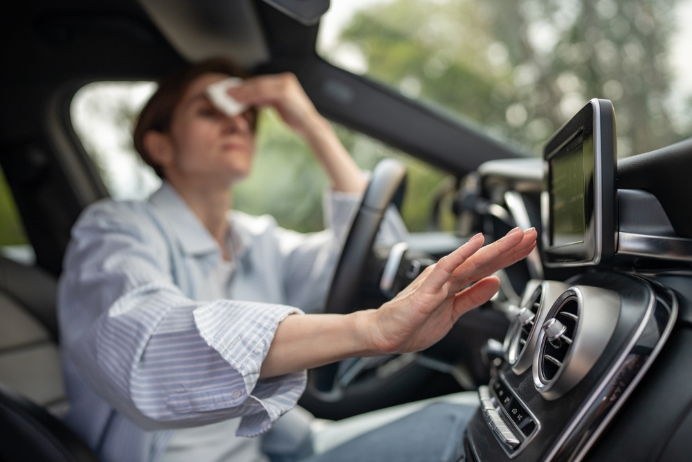 A/C failure symptoms, woman overheating in car, Nissan air conditioning issues Athens GA, Georgia summer car discomfort, Nissan of Athens service needed, hot car interior without A/C, emergency cooling repair Athens Nissan