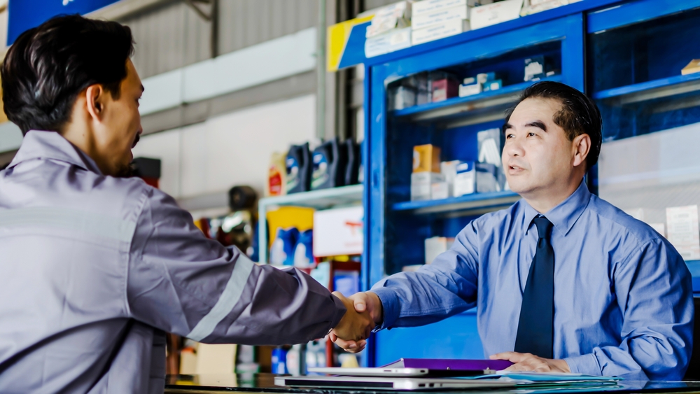 Mechanic answering customer questions about Nissan oil change frequency and oil types.