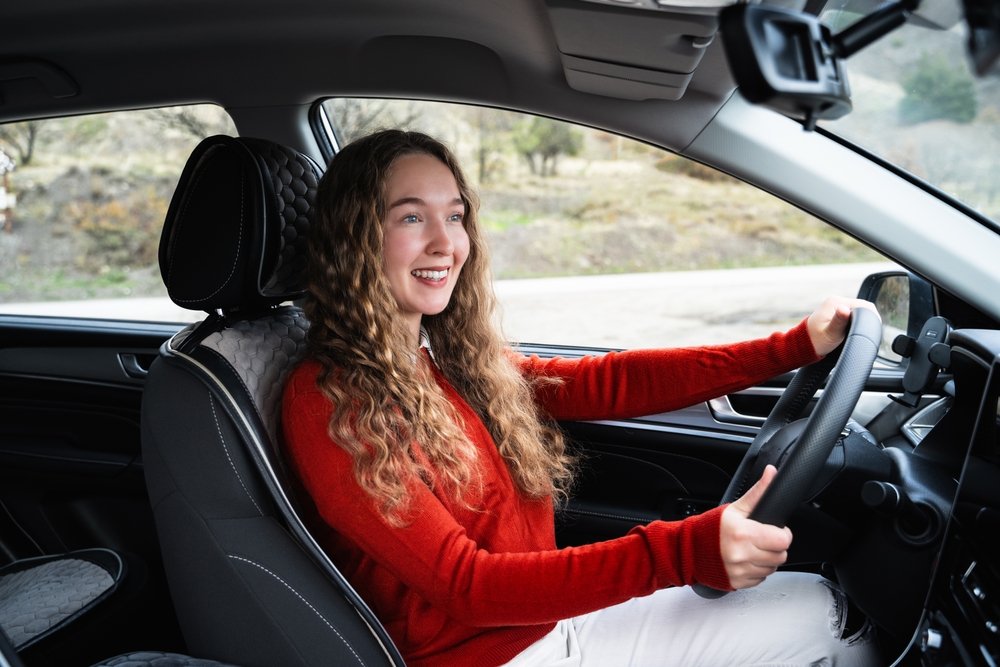Satisfied Nissan driver after alignment service, smooth ride post-alignment Colorado Springs, female driver comfortable steering, confident driver Nissan Colorado Springs, happy customer South Colorado Springs Nissan, wheel alignment service results