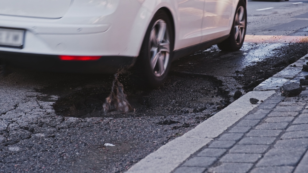 Car hitting pothole on Colorado Springs road, pothole alignment damage, suspension issues from rough roads, Nissan wheel misalignment from pothole impact, alignment problems Colorado elevation, Colorado pothole season, Nissan service after road hazard