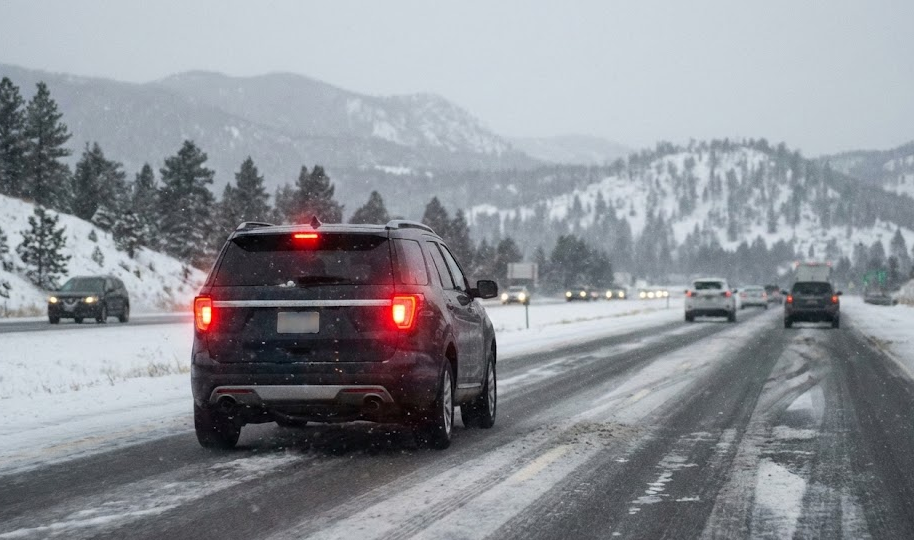 SUV driving on snowy I-25 near Monument Hill, winter storm Colorado Springs to Denver, icy highway traffic conditions, Nissan Rogue or Pathfinder in snow, stopping distance on slick roads, Colorado Code 15 traction law conditions, Palmer Divide winter weather, South Colorado Springs Nissan winter driving tips, Front Range commuter traffic in snow, safe winter highway driving Colorado