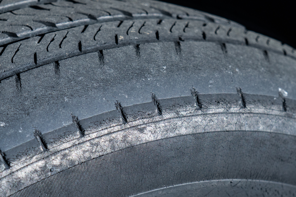Uneven tire wear on vehicle, tire tread wear symptoms, South Colorado Springs Nissan alignment issue, worn-out tires Colorado Springs, feathered tire edge alignment problem, tire damage due to camber misalignment, signs of bad wheel alignment Nissan