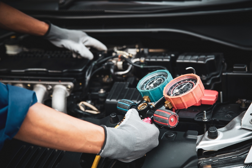 Technician performing Nissan A/C diagnostic, certified Nissan technicians, Nissan A/C service Colorado Springs, air conditioning repair Nissan, genuine Nissan parts, South Colorado Springs Nissan service