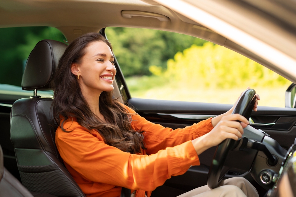Smiling Nissan driver after professional oil change service Knoxville TN, happy customer driving car smoothly, reliable Nissan maintenance near Kingston Pike, Ted Russell Nissan expert technicians, summer heat engine protection, Nissan oil change specials Knoxville, safe and smooth driving experience
