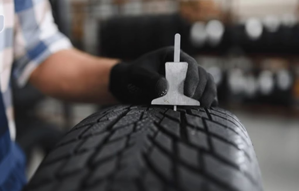 technician measuring tire tread depth with gauge, 4 32 inch tread recommendation for wet leaf driving, INFINITI approved tire inspection Cornelius NC, Lake Norman INFINITI Service Center multi point inspection, checking legal minimum tread vs safe tread, fall tire safety check for luxury SUVs and sedans, tire maintenance for Lake Norman roads covered in leaves