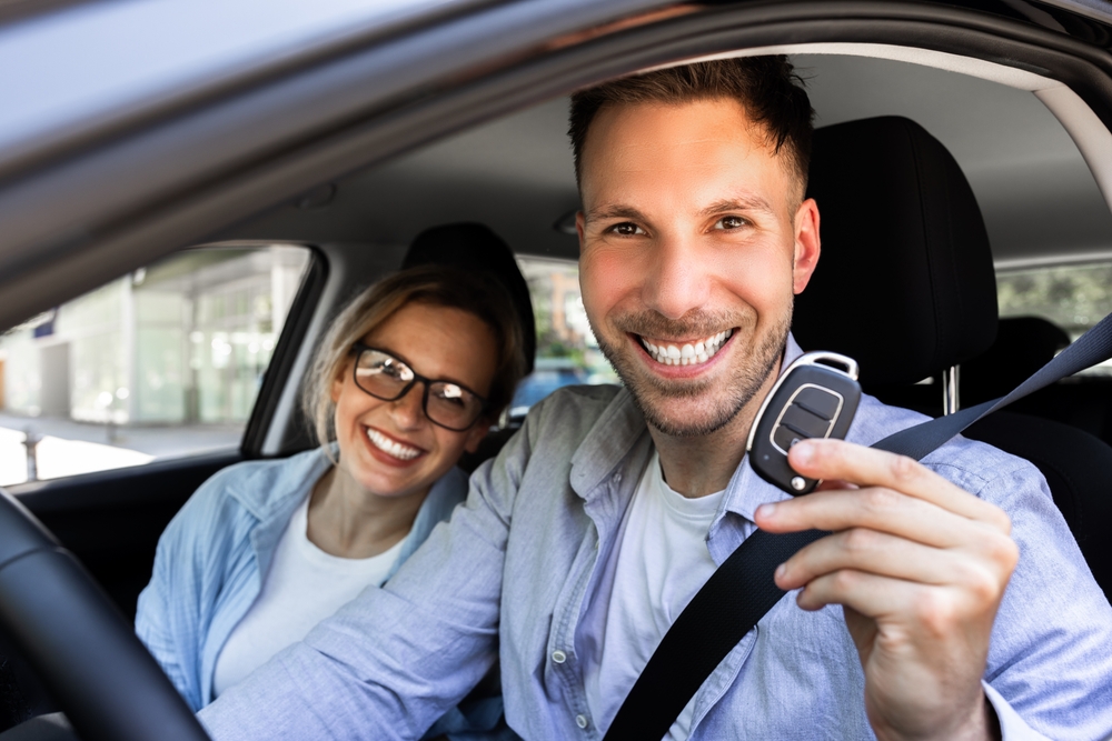 Used car buyers in Manchester NH smiling and holding car keys, used car dealership near me Manchester NH, AutoFair Ford used vehicles, certified pre-owned Ford purchase, affordable used cars under 20000 Manchester