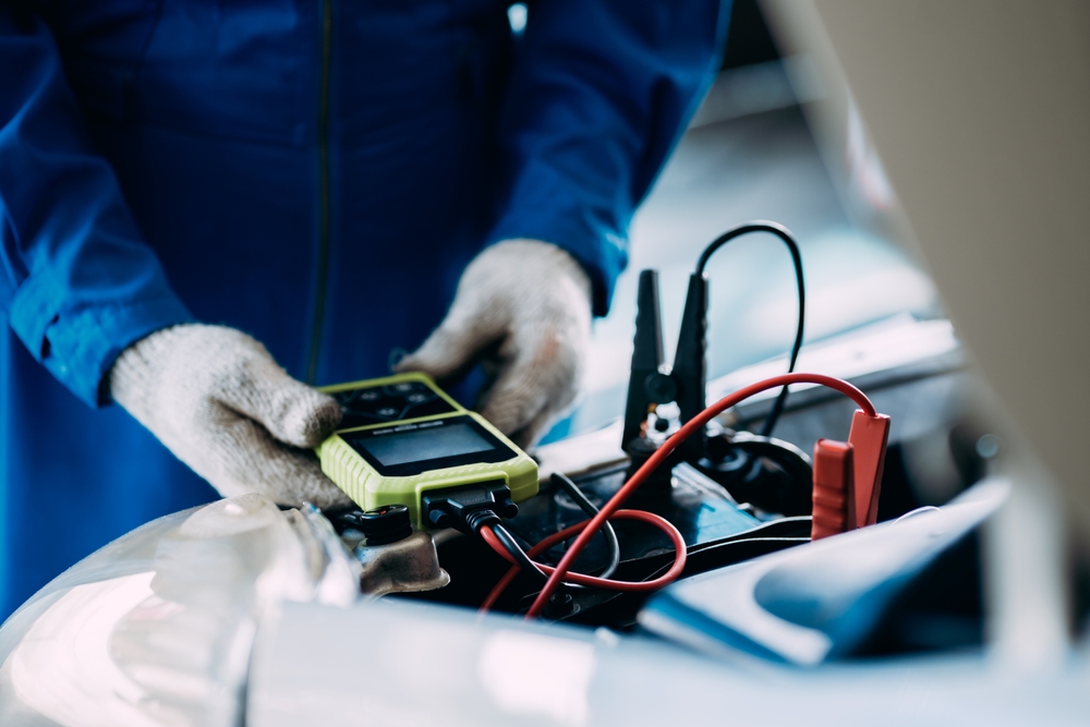 Nissan battery diagnostic test Colorado Springs, professional battery inspection Woodmen Nissan, summer battery service Nissan Colorado, car battery check Vincent Dr Colorado Springs, Nissan charging system test, technician using battery tester Nissan Colorado, prevent battery failure Colorado heat, complimentary battery diagnostic Nissan service center, battery voltage check Nissan Colorado Springs