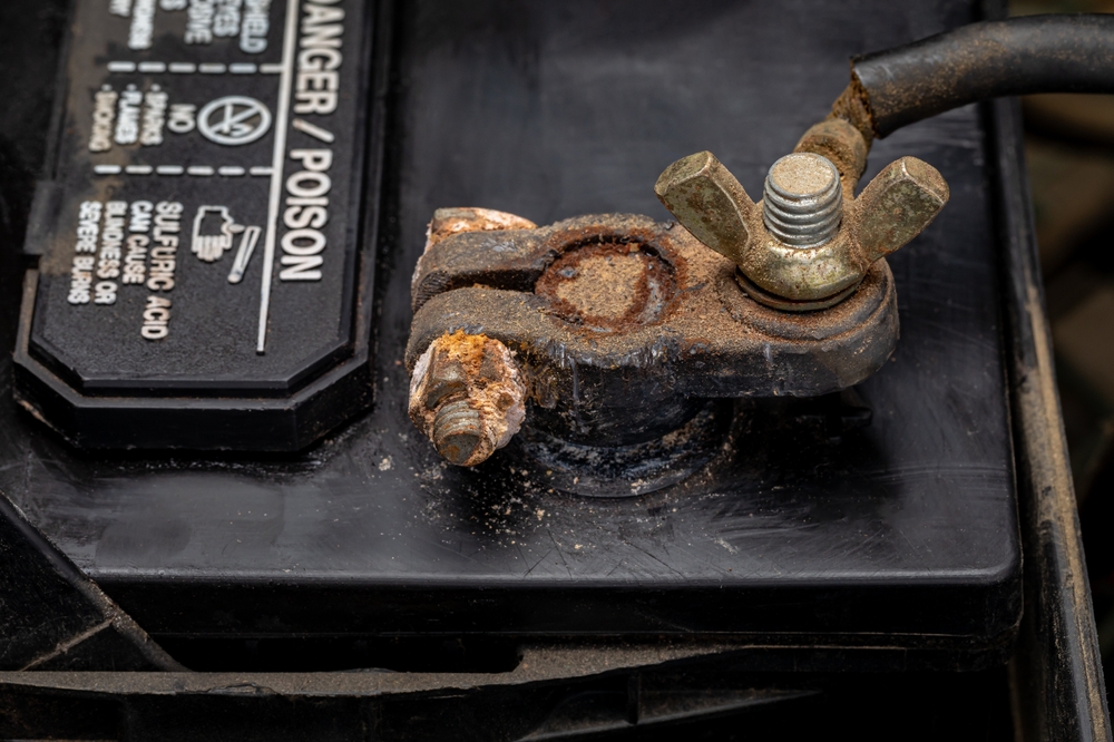 Nissan battery terminal corrosion Colorado Springs, summer battery wear and tear Nissan, corroded car battery connector Woodmen Nissan, signs of battery failure Nissan vehicle, corrosion on battery posts Vincent Dr Colorado, electrical connection issues Nissan hot weather, Nissan maintenance corrosion removal Colorado, battery inspection corrosion buildup, Colorado Springs heat battery damage